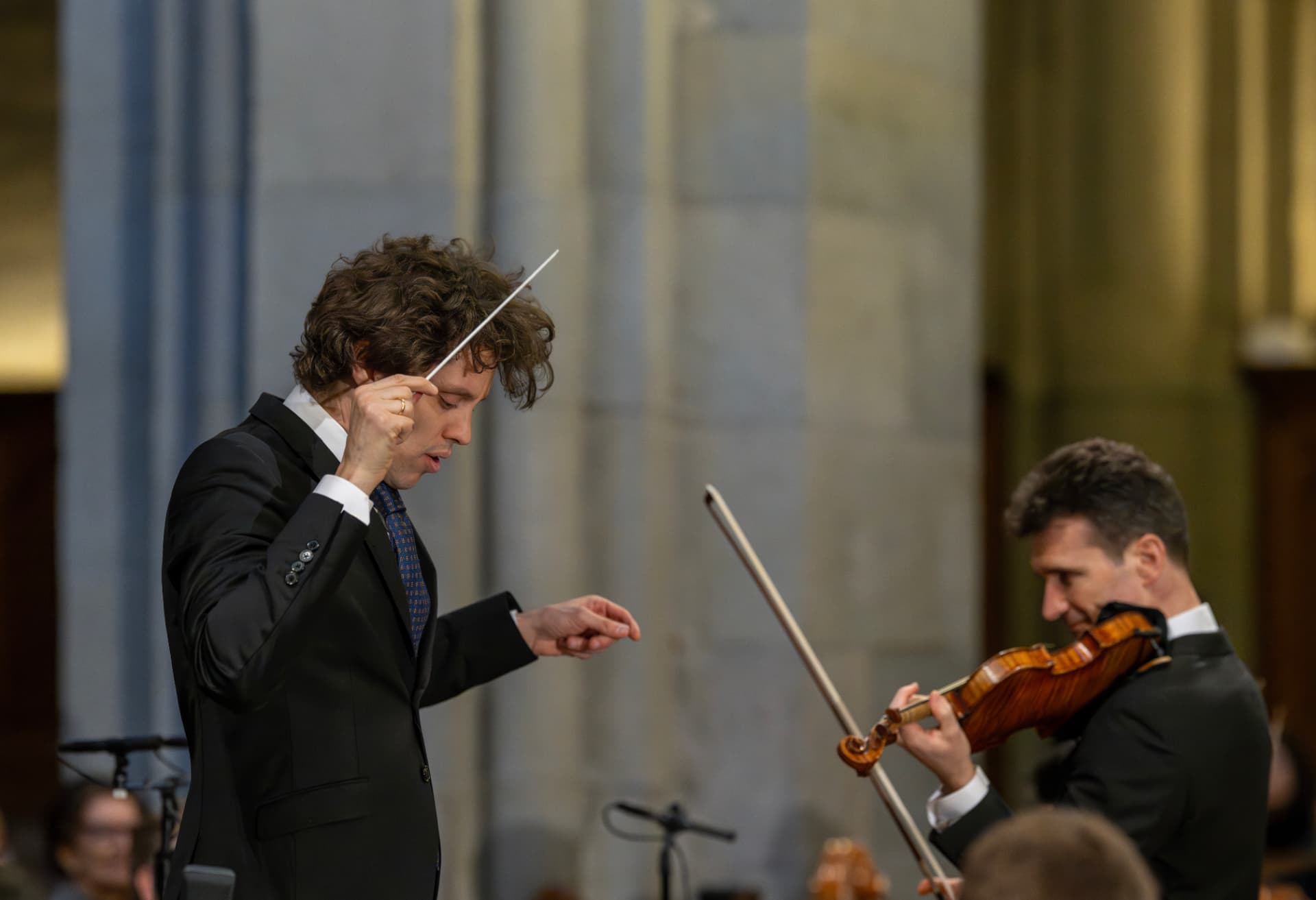 Kevin Griffiths conducting beside the soloist in the church space
